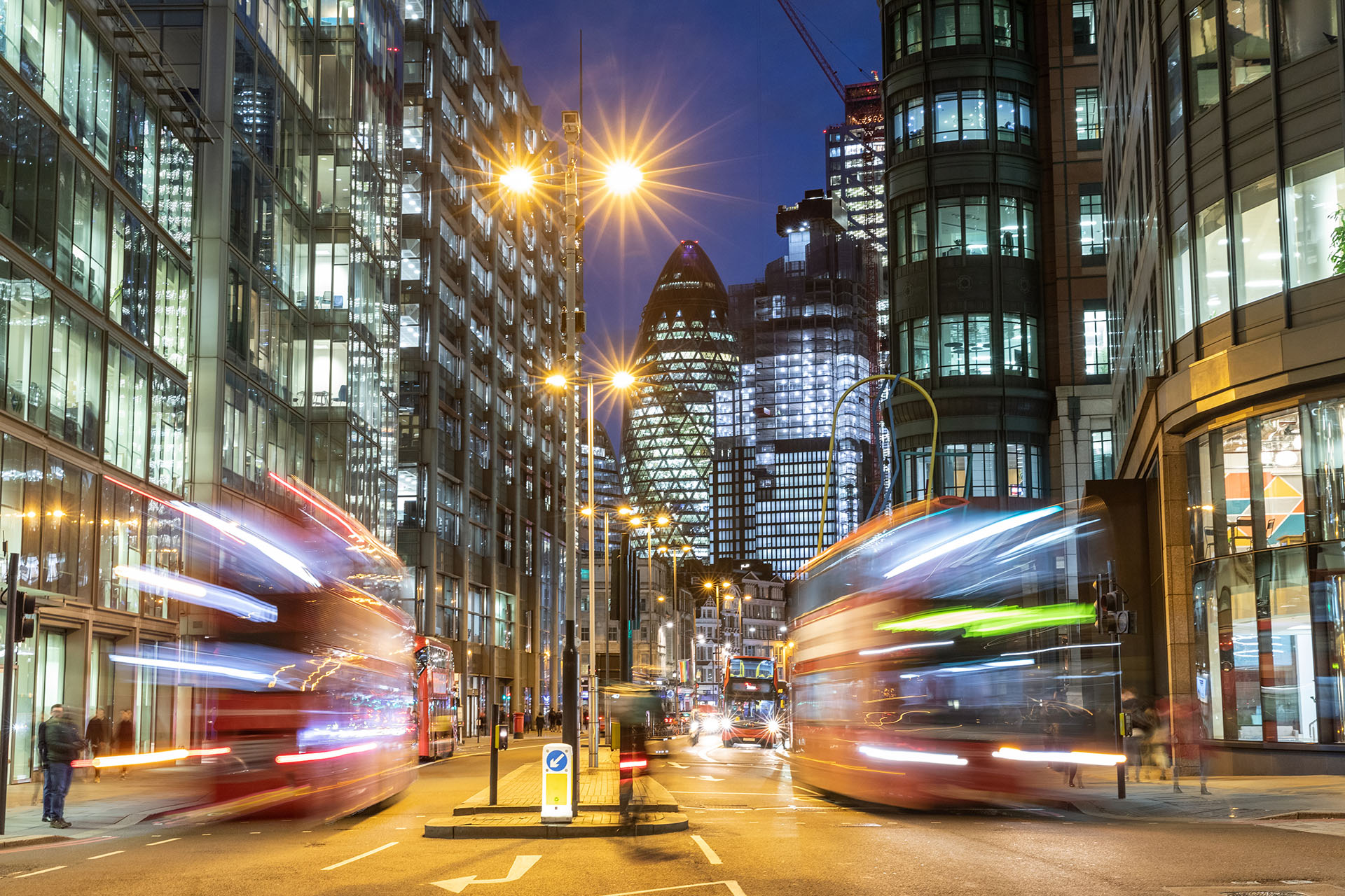Two double decker busses in the evening on the street in the City of London